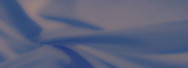 Mavi kumaşın bulanık dokuları zarif desenlere dönüşür, ışığı ve gölgeyi birleştirerek herhangi bir yaratıcı projeye görsel olarak rahatlatıcı ve stil katar..