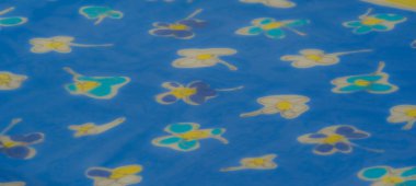 Bulanık etkisi, parlak sarı ve yumuşak beyaz çiçek desenleriyle saf mavi kumaşı güçlendirir. Hafif malzeme ışığı çok güzel yakalıyor.