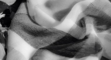 Görüntü, gri tonlu bir kumaşın dinamik kıvrımlarını ve hassas dokularını yakalar. Işığın yüzeyinde çok az ama rafine bir tasarım için ustaca oynadığı bir yer..