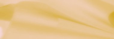 Yumuşak sarı kumaş kıvrımları huzurlu ve pürüzsüz bir görüntü yaratır. Zarif doku arka plan kullanımı veya sanatsal kavramlar için idealdir.