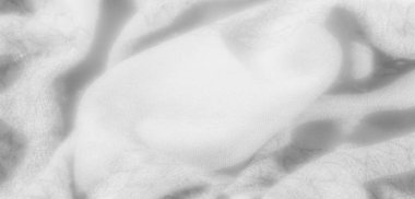 Beyaz kumaşın bulanık dokusu ve kıvrımları, doğal ışık ve gölge oyunuyla yumuşak, havadar bir estetik ortaya koyuyor. Dekor temaları için mükemmel, zarif ve minimalist bir zemin oluşturuyor.