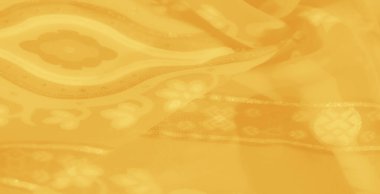 Bulanık sarı kumaş ayrıntılı çiçek desenleri ve parlak bir yüzeye sahip soyut aksanlar, zarif ve geleneksel dekor temaları için idealdir..