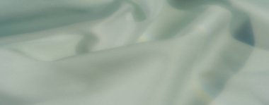Yumuşak dokulu pastel yeşil kumaştan bulanık, zarif perdeler ve sakin bir ortam, yaratıcı arka planlar, lüks tekstil ve estetik tasarımlar için uygun..