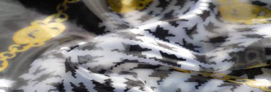 Yumuşak, akışkan katları olan bulanık turuncu kumaş ve görünür dikiş detayları, sıcak ve sanatsal bir tekstil tasarımı için el yapımı çekiciliğin birleşimi.