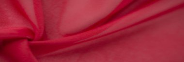 Pürüzsüz kırmızı tekstil, kıvrımlı ve parlak bir kaplama, görsel derinliği arttıran çarpıcı ve zamansız bir görünüm yaratır..