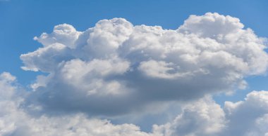 Yumuşak, tüylü beyaz bulutların çarpıcı görüntüsü değişen dokulara sahip parlak mavi gökyüzüne karşı, havadar ve sakin bir atmosfer yaratıyor. Huzurlu bulutlar gökyüzünde yumuşak ve sakin görünüyor..