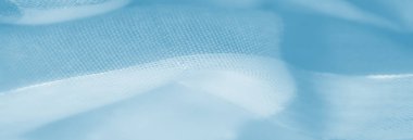 Yumuşak mavi kumaş katmanlarının, birbirine dolanmış ipliklerin ve doğal kıvrımların yansıtıcı dokularla ve rahatlatıcı pastel tonlarla gösterilen rüya gibi bileşimi..