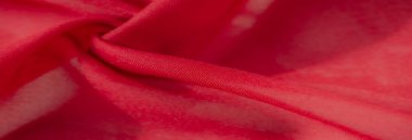 Detaylı kıvrımları ve pürüzsüz dalgalanmaları olan yumuşak kırmızı bir kumaşın bulanıklığı, dinamik ve zarif bir tekstil estetiği için canlı, zengin bir ton..