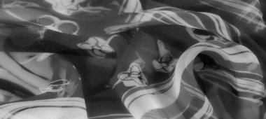 Yumuşak çiçek aksanlı bulanık tek renkli kumaş, zarif kıvrımlar ve pürüzsüz dokular sergiliyor. Gri tonlama minimalist ama büyüleyici bir zarafet yayıyor..