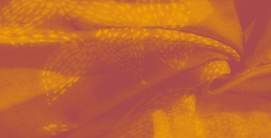 Bulanık, yumuşak kıvrımlı ve desenli turuncu kumaş soyut bir görüntü, sıcaklık ve tarz hissi yaratıyor. Işık dokuyu geliştirir, dekoru veya modayı görsel olarak çekici kılar.