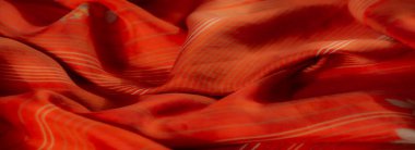 Karmaşık çiçek desenleri ve yumuşak beyaz çizgili turuncu kumaş bulanıklaşmıştı. Yumuşak dokusu ve ılık renk paleti narin bir cazibeyi çağrıştırıyor..