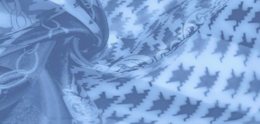 Üst üste binen houndstooth ve zincir motifleri ile canlı mavi kumaş bulanık yakın plan, parlak dokusu ve yaratıcı arka planlar için karmaşık tasarımı sergiliyor.