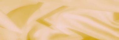 Akan kıvrımları ve yumuşak dokusu olan ince sarı bir kumaşı bulanıklaştır. Malzeme ışığı ve pastel tonlar zarif, sakin ve görsel olarak rahatlatıcı bir görünüm yaratır.