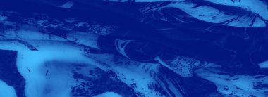 Şebeke desenleri ve yumuşak, akışkan dokuları olan bulanık mavi kumaş. Şekil ve tonların uyumlu karışımı onun zarafetini ve modern sanatsal çekiciliğini vurgular..