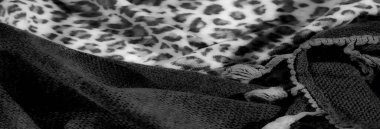 Kalın leopar benekleri olan, yumuşak, tek renkli hayvan desenli kumaş, dokumaya doku ve detay katan sert dokuma malzemesiyle eşleştirilmiş..