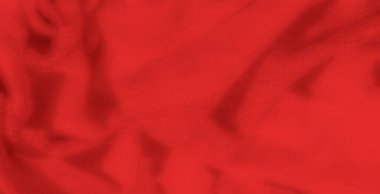 Derin kıvrımları ve yumuşak parıltısı olan lüks kırmızı kumaşın bulanık görüntüsü dokulu bir arkaplan oluşturuyor. Gölgeler bu zarif tekstil yüzeyine derinlik ekler.