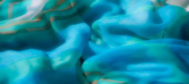 Bulanık mavi saten kumaş zarif kıvrımlar ve ince parıltılar sergiliyor, sofistike ve zarif bir ortam yaratıyor, sanatsal ve tasarım kavramları için mükemmel..