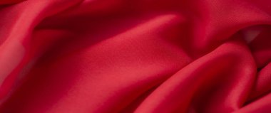 Yumuşak kırmızı kumaşın bulanık görüntüsü ince bir dokuya sahip, canlı tonlara ve pürüzsüz çizgilere sahip, tekstil, arkaplan veya yaratıcı projeler için mükemmel.