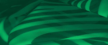 Çağdaş estetik ile dinamik ve şık bir tasarım yaratan, yumuşak dokular boyunca akan koyu soyut çizgilere sahip yeşil kumaş bulanıklığı..