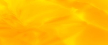 Zarif kıvrımları ve kıvrımları olan parlak sarı kumaş bulanıklığı, zarafeti ve yumuşaklığı vurgulayan pürüzsüz ve parıldayan bir doku sunuyor, arka planlar için harika.