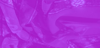 Görüntü. Moda ve dekoratif amaçlar için sanatsal ama işlevsel bir unsur sunan, çiçekli ve soyut desenlerle iç içe süslü, mor bir kumaş..