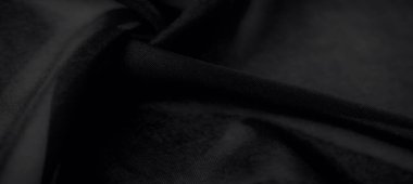 Bulanık siyah kumaşın ipeksi dokusunu vurgular, ışık ve gölgenin hassas etkileşimiyle lüks ve stilin özünü yakalar..