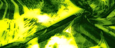 Görüntü. Karmaşık siyah soyut desenleri ve kıvrımları olan canlı yeşil bir kumaş, çarpıcı bir şekilde aydınlatılmış dokulu ve şeffaf bir materyal sergiliyor.