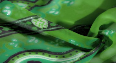 Bulanık, mor ve beyaz motiflerle süslenmiş bu canlı yeşil kumaşın dokulu güzelliğini artırarak büyüleyici ve zarif bir görünüm yaratıyor..