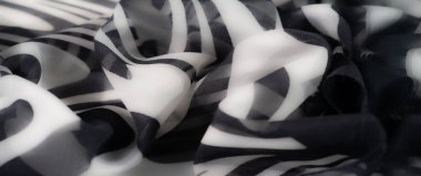 Modern siyah beyaz çizgili yumuşak, katlanmış kumaş bulanıklığı. Monokromatik tonlar ve dalgalı şekiller cesur, minimalist bir görünüm sağlar..