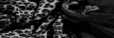 Karmaşık tasarlanmış kumaşların tek renkli görüntüsü kalın örgülü iplerle kalın hayvan izlerini birleştirerek dinamik ve sanatsal bir görsel doku yaratıyor..