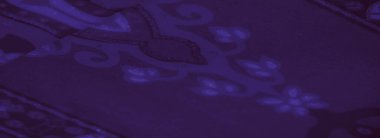 Işıldayan geometrik tasarımları ve akışkan dokuları olan yumuşak mor kumaşın bulanık görüntüsü, sanatsal arkaplanlar için bir gizem ve zarafet hissi uyandırıyor..