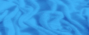 Yumuşak kıvrımlı, akışkan, pürüzsüz mavi kumaş ve ince bir doku, sakin, soyut bir kalıp yaratıyor ve kumaş tasarımına derinlik katıyor..