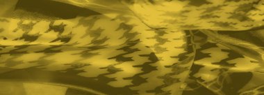 Kalın zincir elementleri ve soyut şekillerle süslenmiş bulanık sarı kumaş, parlak bir dokuyla çarpıcı ve sanatsal bir desen kombinasyonu oluşturuyor..