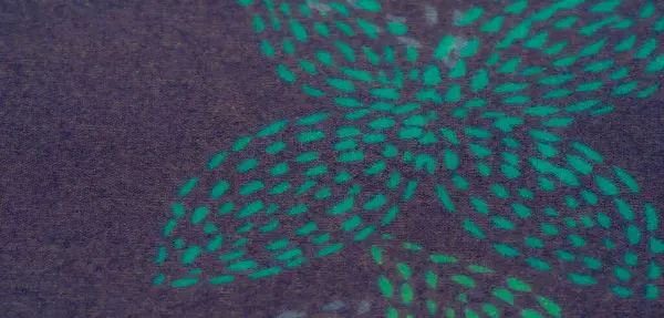 Mavi ve yeşil desenli mor bir kumaşın bulanıklığı çarpıcı bir renk ve doku oyunu ortaya çıkarmak için karmaşık bir şekilde katlanmış. Soyut tasarımlar ve kumaşla ilgili konular için uygundur