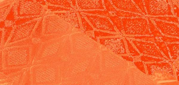 Karmaşık geometrik desenleri ve su damlacıkları olan turuncu dokuya yakın çekim bulanık görüntü. Kumaş parlak görünümlü canlı ve zengin bir renk sergiliyor..