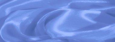 Zarif kıvrımları ve yumuşak ışıklandırması ile bulanık mavi kumaş pürüzsüz saten dokuyu yakalar, huzurlu ve lüks bir görünüm yaratır..