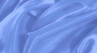 Zarif kıvrımları ve yumuşak ışıklandırması ile bulanık mavi kumaş pürüzsüz saten dokuyu yakalar, huzurlu ve lüks bir görünüm yaratır..