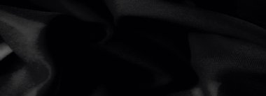 Görüntü, yumuşak, dalgalı kıvrımlı siyah kumaştan oluşan soyut bir düzenleme ve lüks bir mat bitirme, yaratıcı tasarım kavramları veya moda için mükemmel..