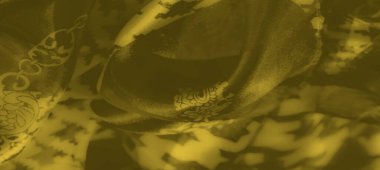 Üst üste binen zincir ve geometrik şekilli bulanık sarı kumaş. Akan tasarım, soyut ve yapısal estetik arasındaki dengeyi vurgular..