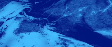 Bulanık beyaz, karmaşık, dantel benzeri tasarımları olan yumuşak mavi bir tekstil vurgular, zengin dokular ve hassas bir kapanış ile sakin bir görsel cazibe yaratır.