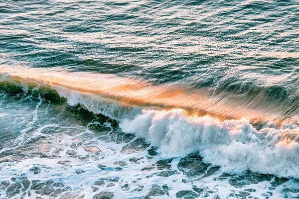 Sea wave and golden sunset reflection, Pacific Ocean, California, USA, close-up. Beautiful scenery, and background