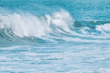 Dalga yakın planda sıçrıyor. Kristal berrak deniz suyu okyanusta, San Francisco Körfezi 'nde kaya oluşumlarına çarpar. Mavi su, pastel renkler..