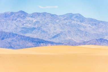 Ölüm Vadisi, Kaliforniya, ABD 'deki dağların ve gökyüzünün arka planında kum tepeleri