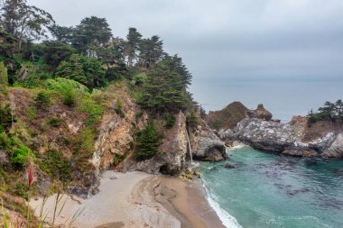 1. Otoyol ve Big Sur boyunca Pasifik Okyanusu 'nun güzel manzarası, yukarıdan McWay Falls manzarası, gün batımı, gün doğumu, sis. Kavram, seyahat, tatil, hafta sonu.