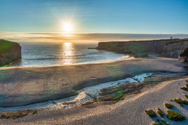 Kaliforniya 'daki 1. Otoyol boyunca güzel bir gün batımı manzarası. Körfez boyunca uzanan Pasifik Okyanusu kıyı şeridi, hava manzaralı. Seyahat ve tatil kavramı.