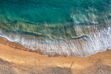 Beach sand sea water summer background. Sand beach desert texture. White foam wave sandy seashore top view.