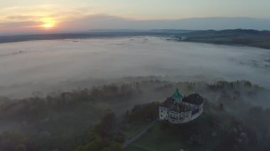 Hava görüntüsü. Lviv şehri yakınlarındaki Ortaçağ Olesko şatosu. Resimli bir tepenin üzerinde duruyor. Havadan. Bu, 13-18 asırlık eşsiz bir mimari ve tarih anıtı. İnsansız hava aracı görüntüleri. 4K