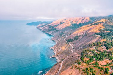 Pasifik Okyanusu kıyısı boyunca uzanan 1. Otoyol ve Big Sur, güzel manzara ve hava manzarası, gün batımı, gün doğumu, sis. Kavram, seyahat, tatil, hafta sonu.