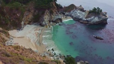 California 'daki 1. Otoyol boyunca Pasifik kıyısındaki McWay Şelaleleri' nin havadan görüntüsü. Büyük Sur, Lucia. Seyahat konsepti, turizm, seyahat, tatil. 4K video.