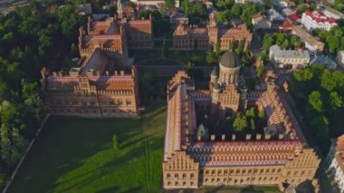 İlahiyat Fakültesi 'nin ve Üç Azizin Kilisesi' nin havadan görünüşü. UNESCO. Mimari. Kuleleri, kubbeleri ve yeşil bahçesi olan eski tarihi üniversite binası Chernivtsi, Ukrayna. Video 4k